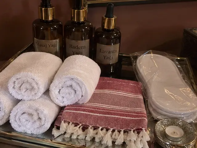 Masaj yağları, rulo havlular, kırmızı çizgili peştemal ve terlik — Yeşilpınar, Masaj Salonun