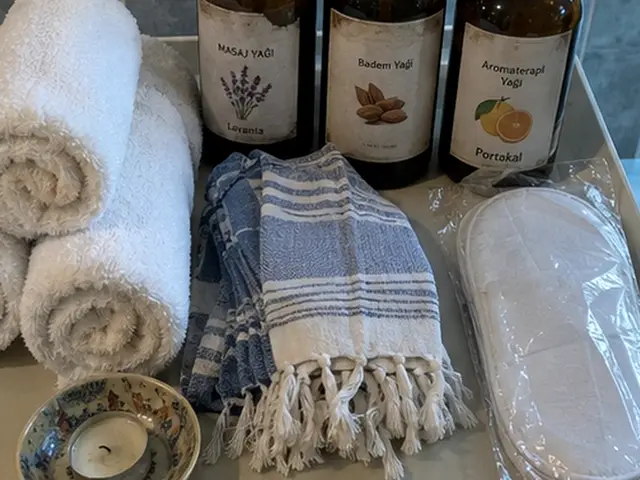 Rulo havlular, mavi peştemal ve aromaterapi yağları — Yeşilpınar, Masaj Salonun